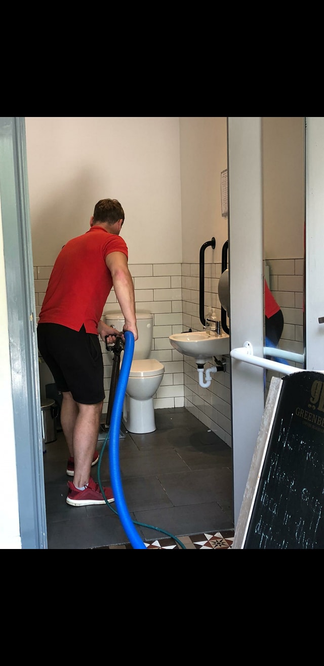 Tile and grout cleaning being carried out in a commercial washroom